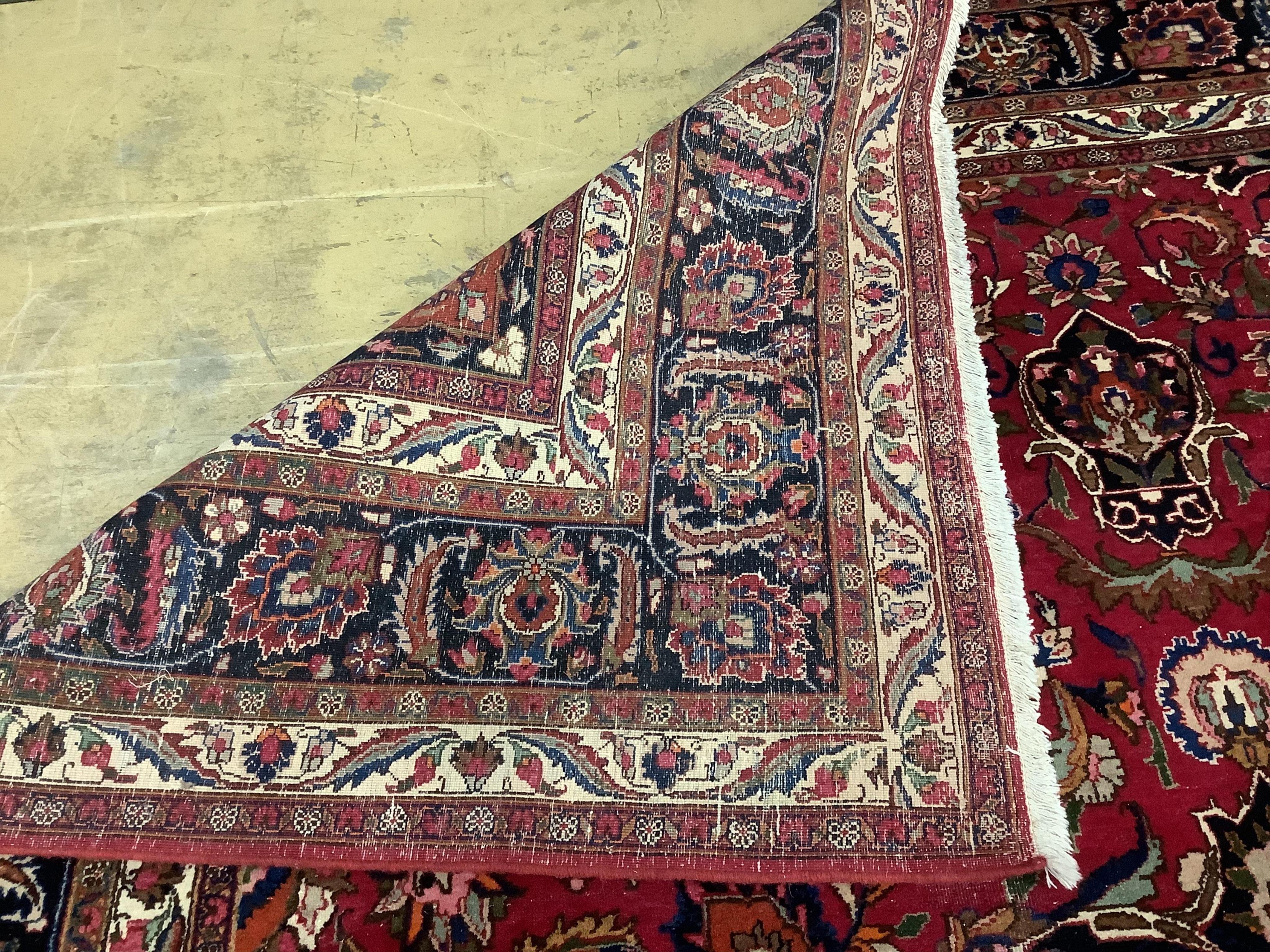 A Heriz burgundy ground floral carpet, 392cm x 299cm. Condition - good